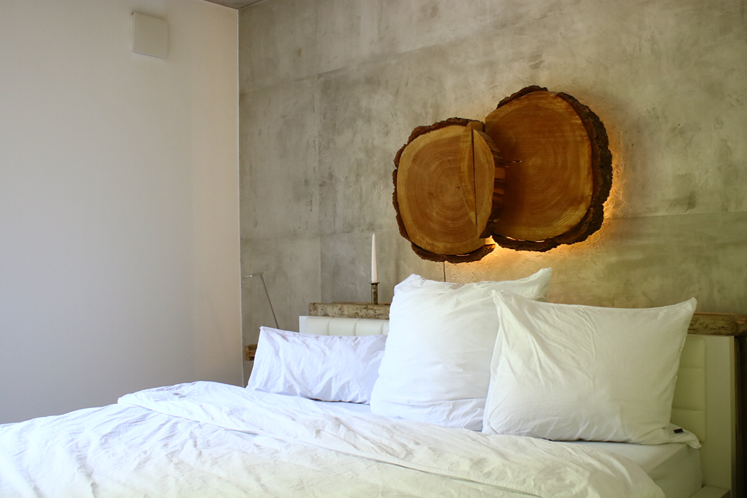 Bild einer Bettes mit Holz Lampe